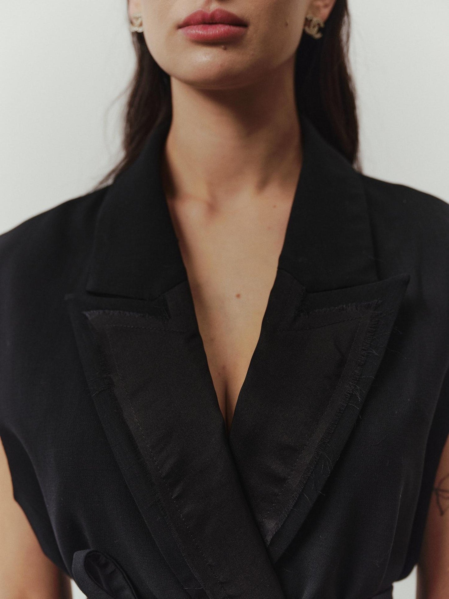Tailored sleeveless jacket with accent silk lapels and belt