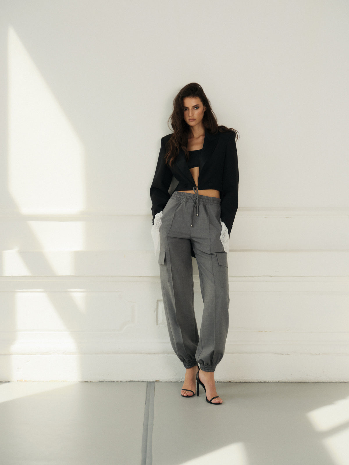 Cropped fitted tailcoat in black wool with accent satin lapels and lace cuffs